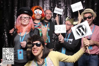 Several WordPress themers with holding crazy props and wearing wild hats in a photo booth.