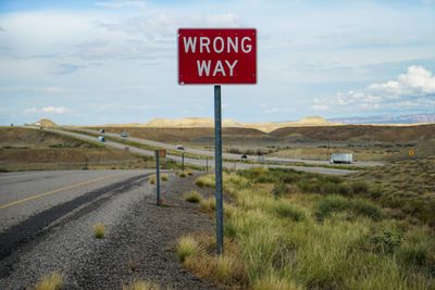 Red wrong way sign on road.