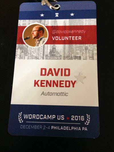 WordCamp US 2016 conference badge with red, white and blue design, stars, leafs and the words David A. Kennedy.