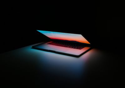 Gray and black laptop computer on dark surface.