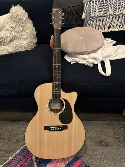 A Martin full-size acoustic guitar with a classic spruce top and a black pickguard.