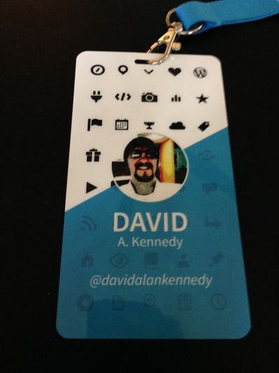 Blue and white conference badge with social media icons and the words David A. Kennedy, Automattic Grand Meetup 2014.