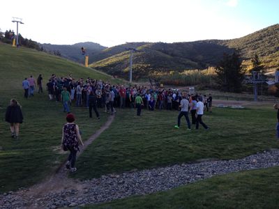 A bunch of people in a field trying to line up for the company photo.