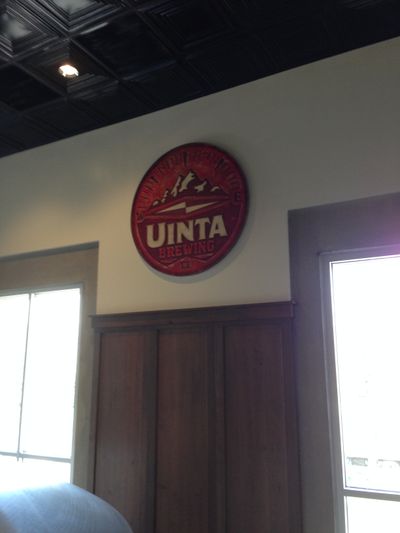 One of the Uinta Brewing Company signs, which has white lettering over a red background with mountains in the center.