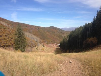 Holly Trail at Canyons Resort, overlooking a grassy field with mountains in the background.