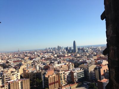 A view of Barcelona from atop La Sagrada Familia, an ornate church in Barcelona, Spain. A stone pillar fills out the edge of the right side.