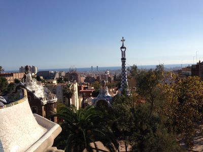 A view from Parc Güell, in Barcelona, Spain, looking toward the ocean dotted with buildings.