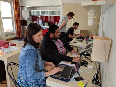 Several people sitting at tables working on computers.