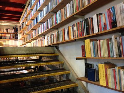 A giant book store in Lisbon, showing stairs and a large bookshelf spanning a whole wall.