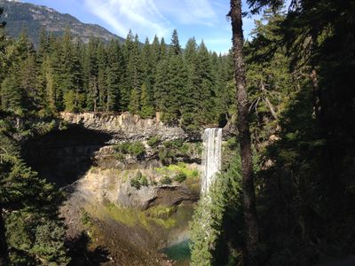 Brandywine Falls, near Whistler, British Columbia. A waterfall pours down the side of a cliff amid a forest of trees.