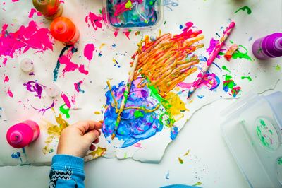 Flat photography of paintings, which include streaks of yellow, pink, orange and blue.